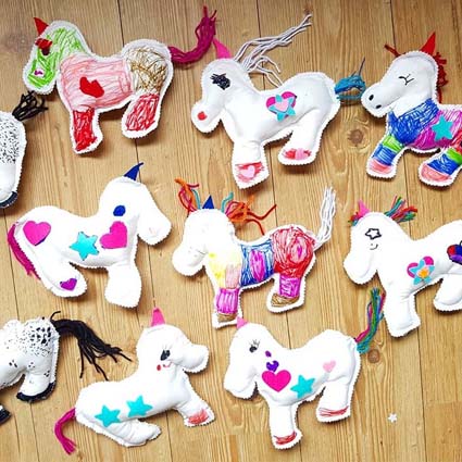 Verschillende door kinderen gemaakte unicornknuffels tijdens een kinderfeestje.